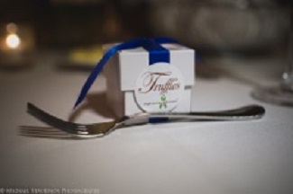 Close up of Erica & Matt's chocolate truffles wedding favor tied with a royal blue ribbon.