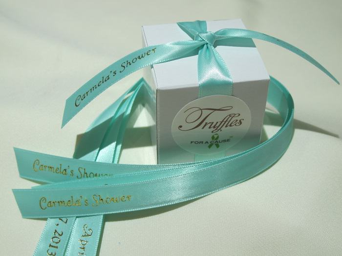 Chocolate shower favors displayed with aqua ribbons and a white box for bridal shower.