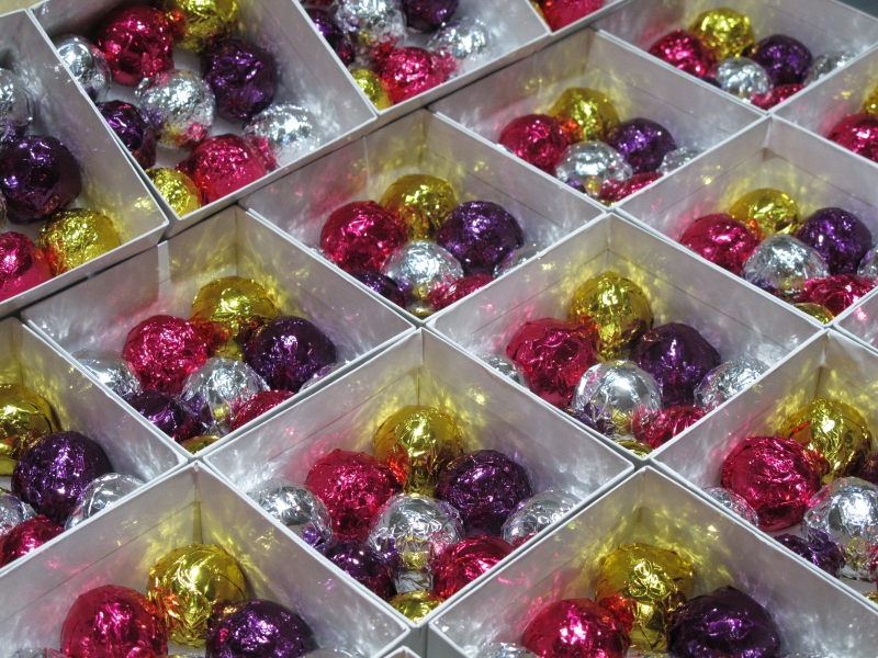 Deluxe Foil Production with 9 asssorted chocolate foil truffles visable in each favor box.
