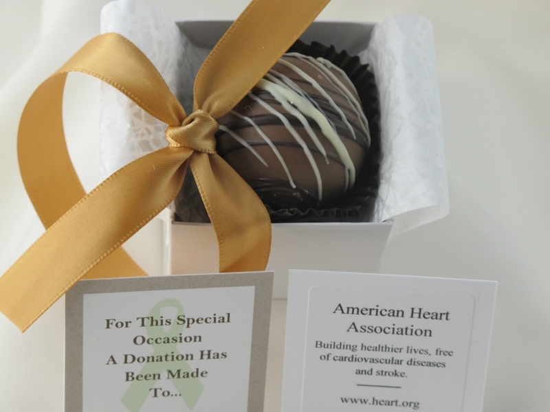 Gold ribbon with open Dessert Favor displaying caramel chocolate dessert truffle in box.